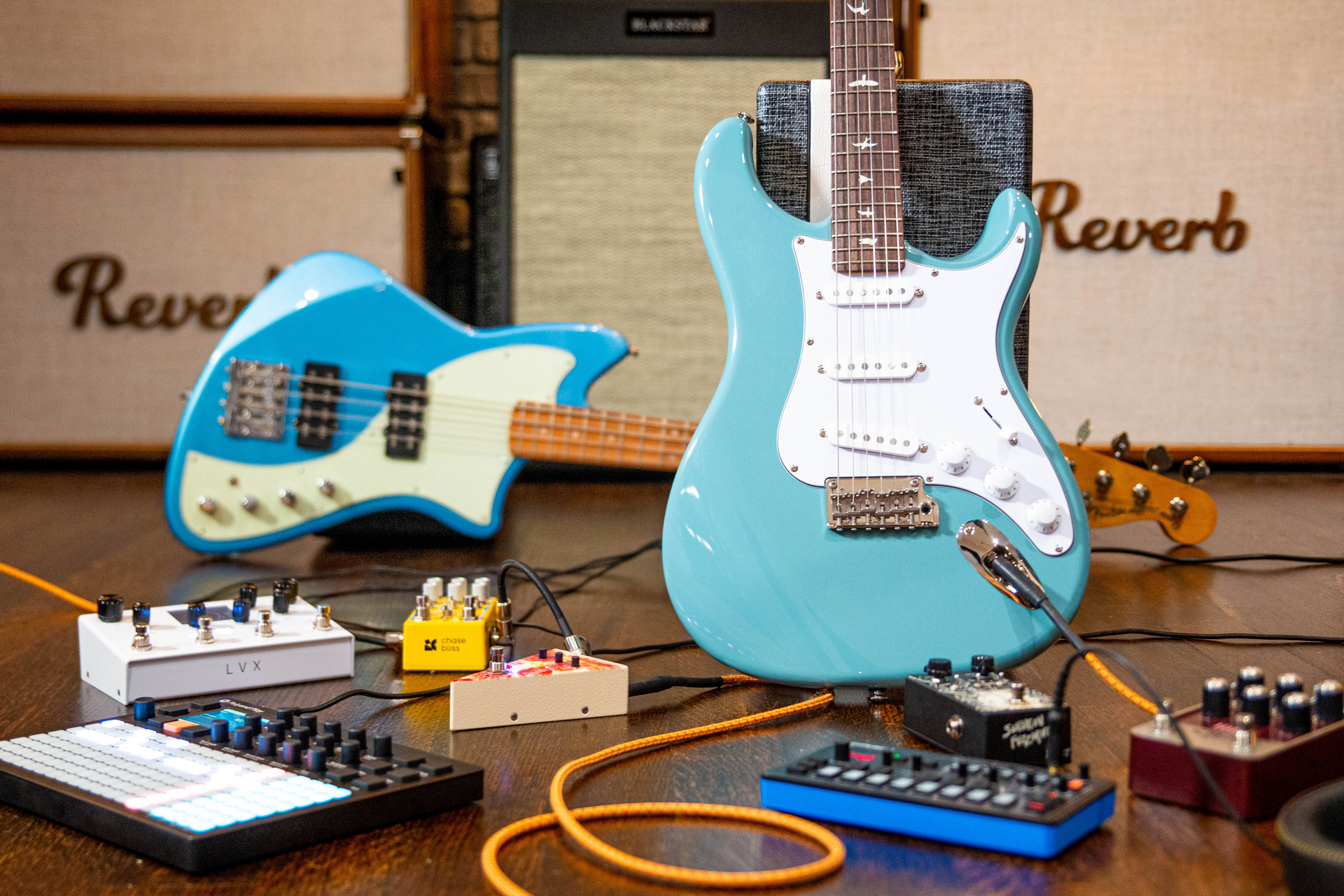 Photo of a Fender stratocaster guitar, Meteora bass, and various guitar pedals